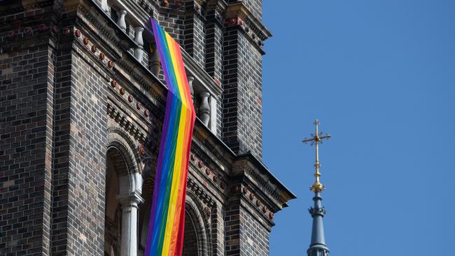 A LGBT rainbow flag hangs from on the steeple of the parish church in the Breitenfeld quarter in Vienna, on March 25, 2021. The Vatican on December 12, 2023 approved blessings for same-sex couples but insisted they must not be established as a Catholic rite nor given in contexts related to civil unions or weddings. Picture: ALEX HALADA /AFP