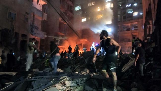 Lebanese civil defence members and other people inspect the site of an Israeli airstrike on the Basta neighbourhood of Beirut on October 10, 2024. Israel expanded operations in Lebanon nearly a year after Hezbollah began exchanging fire in support of its ally, Hamas, following the Palestinian group's deadly attack on Israel on October 7, 2023. (Photo by AFP)