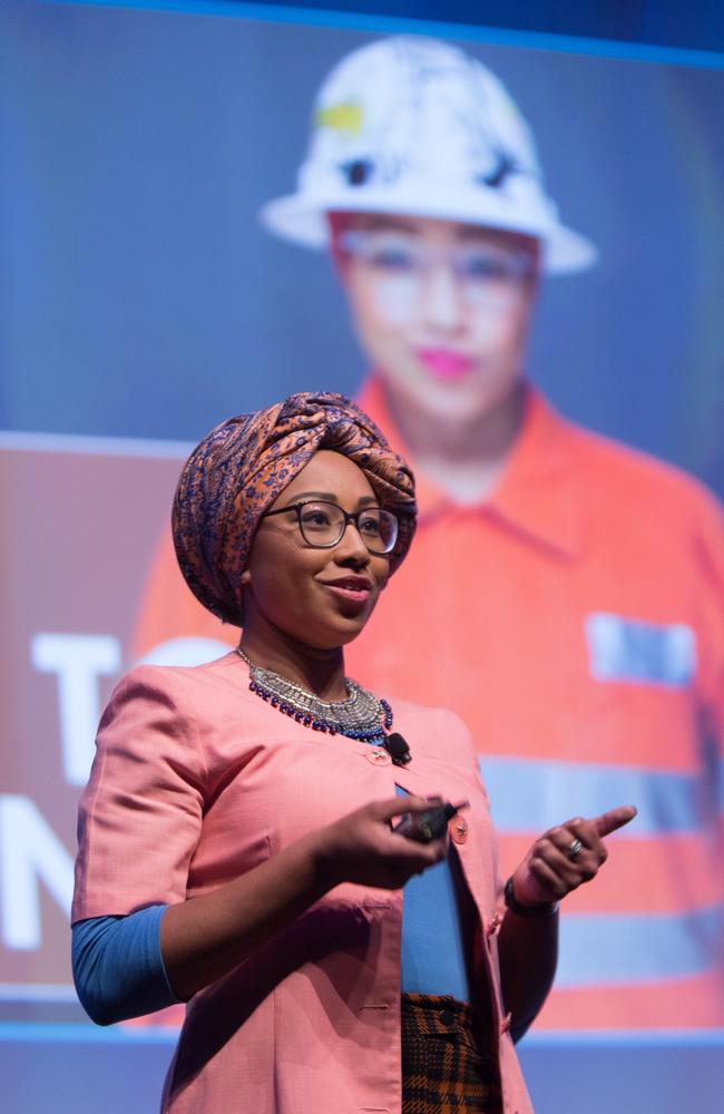 Yassmin Abdel-Magied last year standing in front of a photo of herself in high vis gear working as a mechanical engineer.