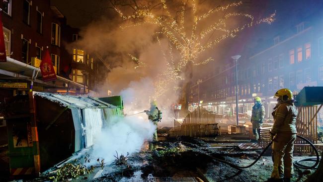 Firefighters work to extinguish a fire on the Groene Hilledijk in Rotterdam after a second wave of riots in the Netherlands following the introduction of a coronavirus curfew. Picture: AFP