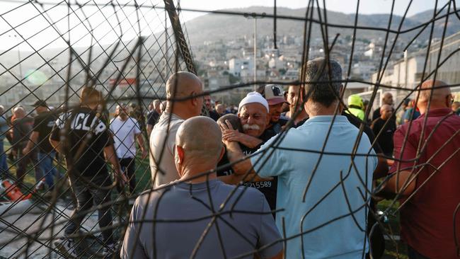 Local residents comfort each other after the strike. Picture: AFP