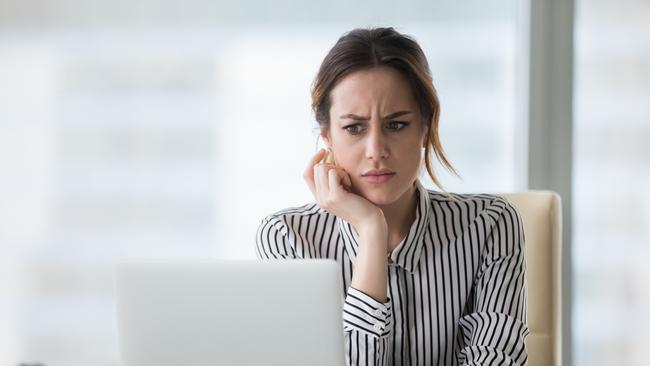 Confused businesswoman annoyed by online problem, spam email or fake internet news looking at laptop, female office worker feeling shocked about stuck computer, bewildered by scam message or virus