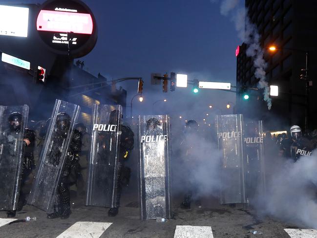 Atlanta police prepare to enforce a 9:00 pm curfew with gas as demonstrators chant, Tuesday, June 2, 2020, in Atlanta. Protests continued following the death of George Floyd, who died after being restrained by Minneapolis police officers on May 25. (AP Photo/John Bazemore)