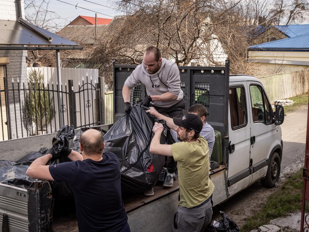 Bodies are loaded into a truck. Picture: Getty Images