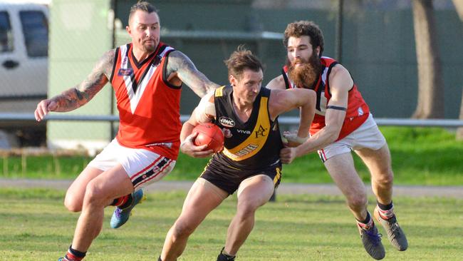 Christies Beach’s Mathew Hodge and Adam Britten tackle Aldinga's Eliot Schneider during the side’s clash on Saturday. Picture: AAP/Brenton Edwards