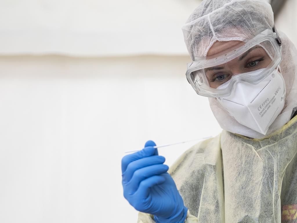 A medical worker wears PPE while taking a swab sample outside at a COVID-19 testing station. Picture: Maja Hitij/Getty Images