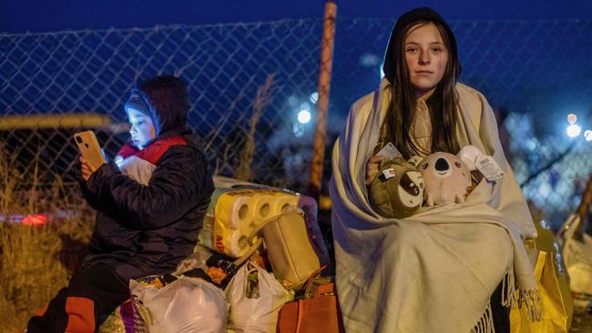 Helena, right, and her brother Bodia from Lviv at the Medyka pedestrian border crossing, in eastern Poland, on Sunday (AEST). Picture: AFP