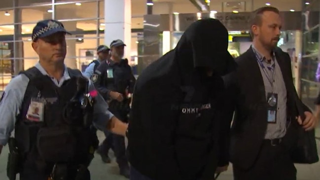 Police escort a Sydney man facing child sexual assault charges through Cairns airport. Picture: 7 News