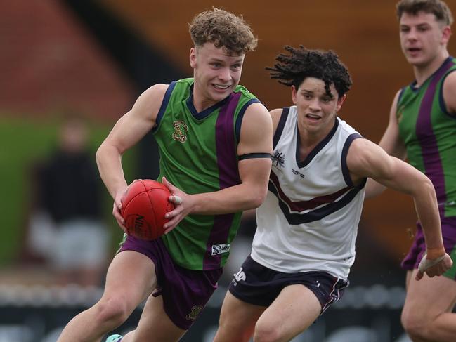 Dylan Costantin of Parade College runs with the ball under pressure from Des O'Keefe of Emmanuel College during the Herald Sun Shield Senior Boys Div 1 Grand Final.