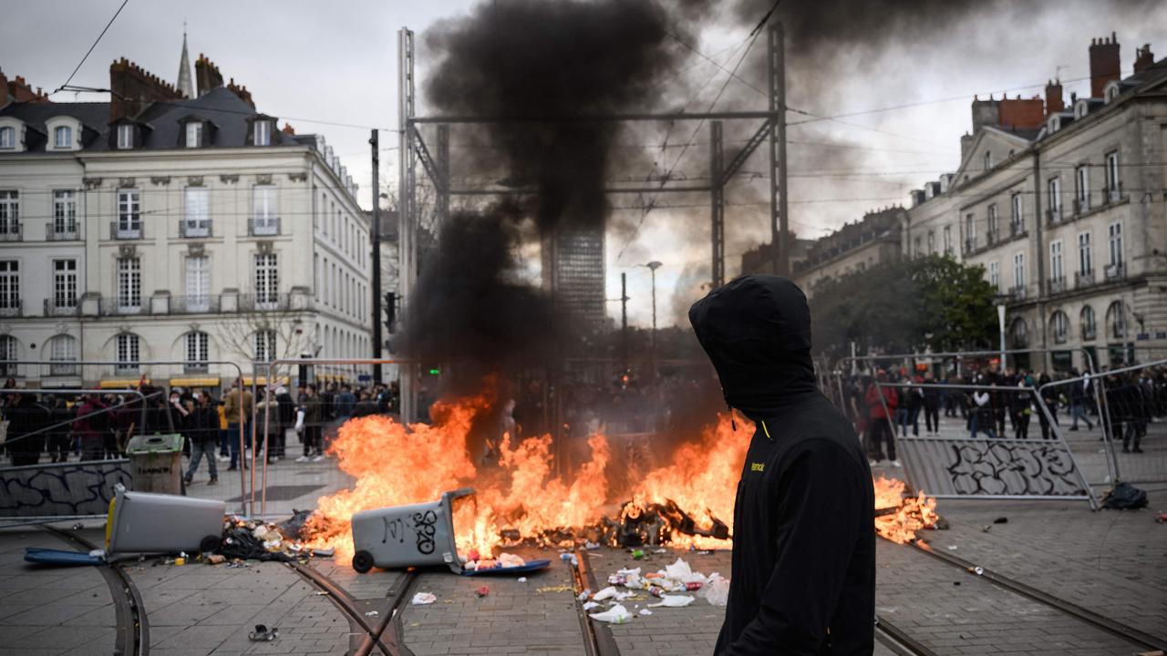 A man passes by a burning barricade during a demonstration in Nantes. Picture: Loic Venance/AFP