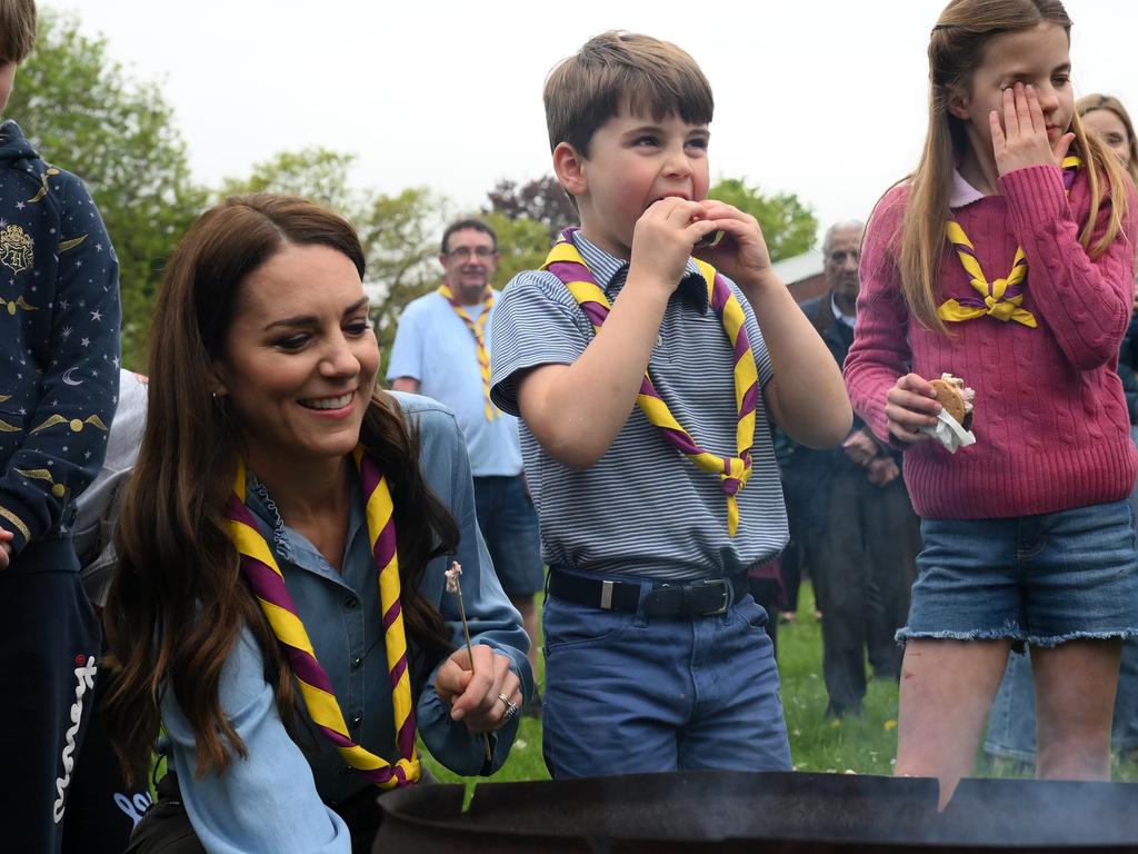 Princess Charlotte (R) shields her eyes from smoke as Prince Louis (C) and Catherine, Princess of Wales toast marshmallows at the Big Help Out. Picture: Getty Images