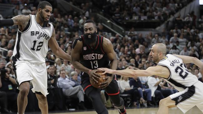 Houston Rockets guard James Harden drives between Spurs forward LaMarcus Aldridge (12) and guard Manu Ginobili (20) in San Antonio yesterday
