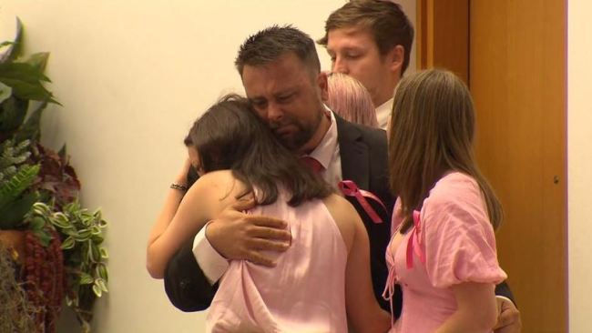 Julie's fiance is comforted by her two daughters at the funeral service. Picture: 7 News