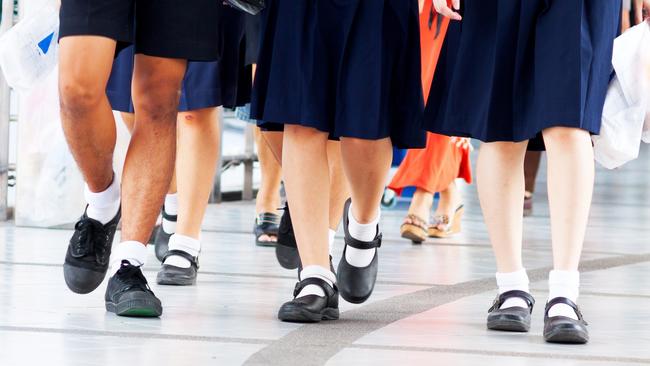 Capture of feet and shoes of students in school uniform and leaving shopping mall and walking over pedestrian bridge.