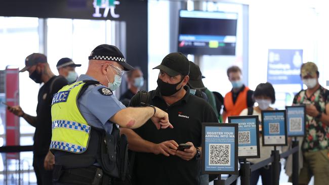 Arriving passengers scan the arrival registration QR codes at the Qantas Domestic terminal in February in Perth. The state recorded another 9243 new Covid-19 cases and six historic deaths on Saturday. Picture: Paul Kane / Getty Images