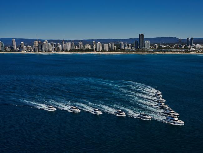 11 Riviera luxury motor yachts moving in line formation arriving at Sanctuary Cove Marina for the boat show.