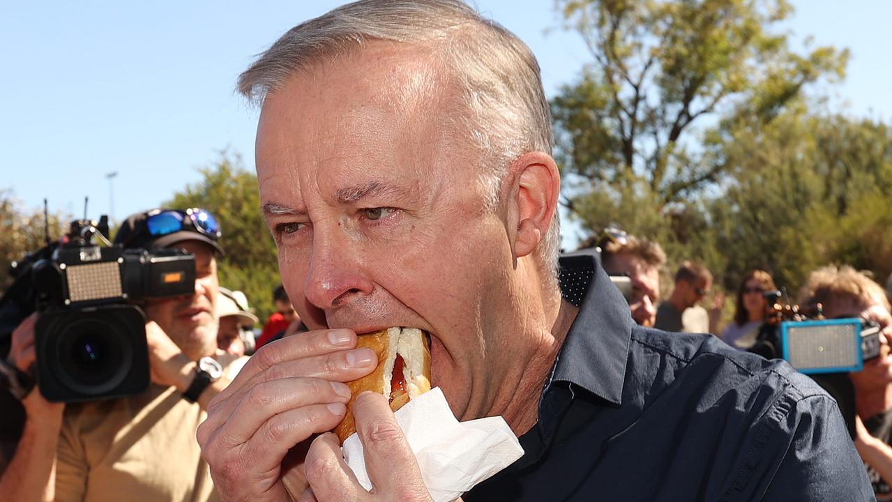 Labor leader Anthony Albanese engulfs a sausage while visiting a BBQ for Labor volunteers in the seat of Cowan WA. Accompanied by Labor’s Bill Shorten and federal member for Cowan Dr Anne Aly. Picture: Liam Kidston