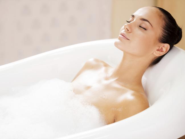 Beauty in bubble bath. Side view of attractive young woman keeping eyes closed while enjoying luxurious bath.