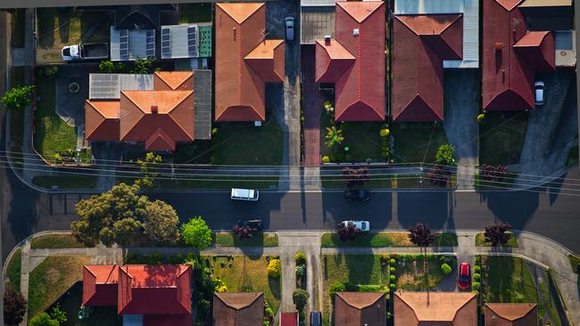 Flying over the suburbs of Melbourne; Community; Housing Development; Railroad Crossing; Crossing; Urban Scene; Aerial View; High Angle View; Melbourne - Australia; Roof; Street; Suburb; Residential District; City; Aerial Photograph. For group read story on rooming house laws. iSTOCK