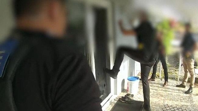 Police footage shows an officer breaking down the front door of a home during raids targeting alleged members and associates of the Mongols Outlaw Motorcycle Gang in Cairns.