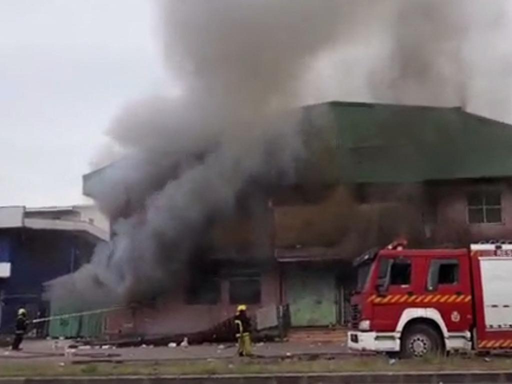 Firefighters at a building after protesters set alight buildings and attempted to storm the parliament in the Solomon Islands' capital Honiara, which has since been placed under curfew. Picture: Courtesy of Jeremy Gwao / AFP