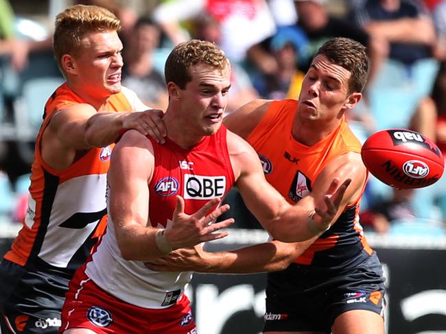 Tom Mitchell is tackled by two GWS players.