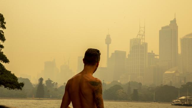 A man looks over a smokey Sydney skyline on December 19, 2019 during the Black Summer bushfires. Picture: Jenny Evans/Getty Images