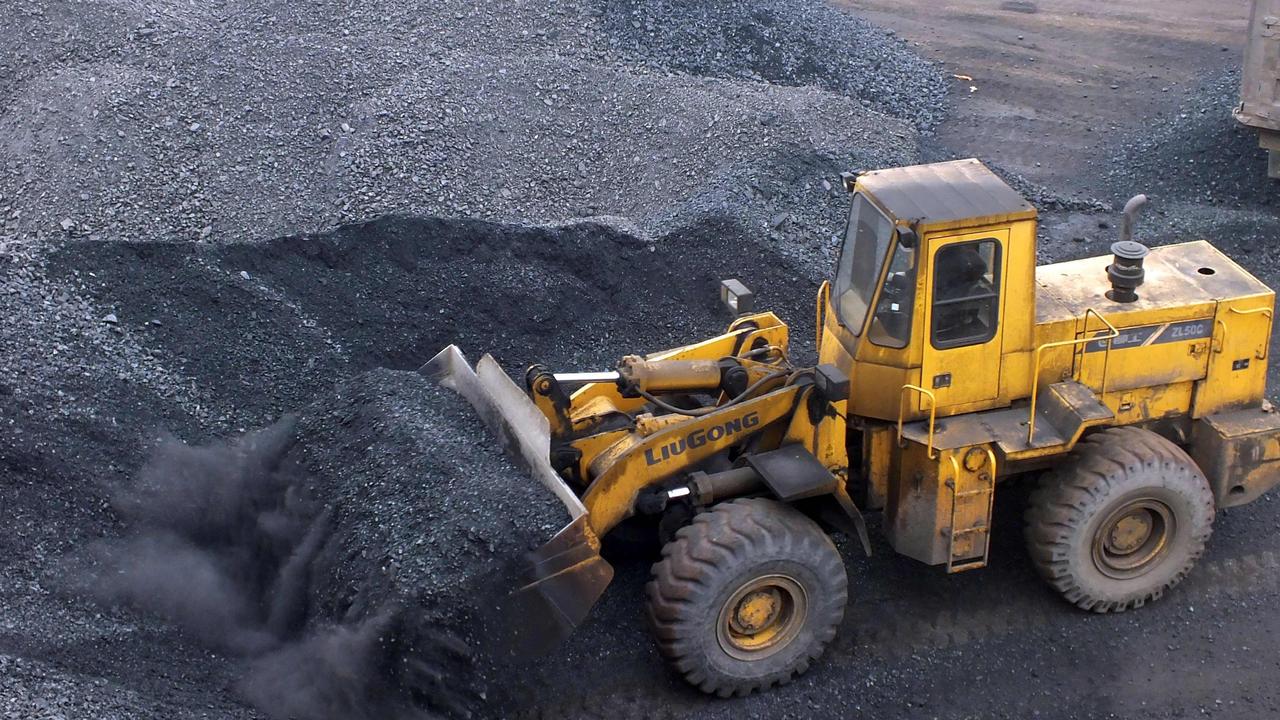 An excavator moving coal onto a truck at a port in Yichang, central China's Hubei province. Picture: AFP