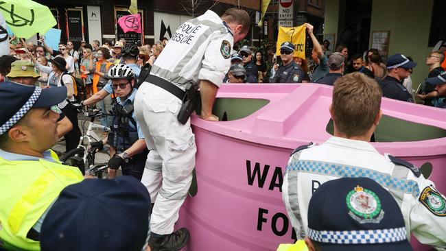 Police assess how to extract protestors out of the locked water tank on Monday. Picture: Richard Dobson