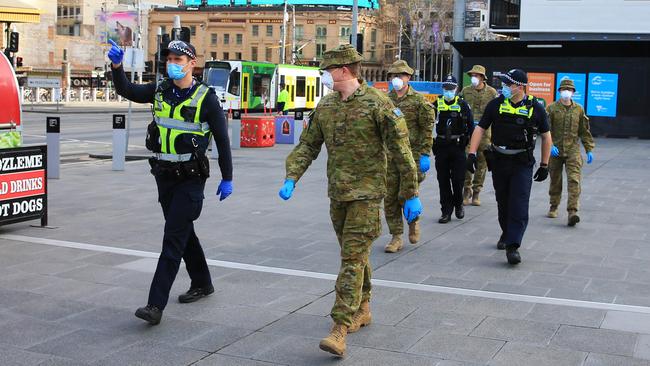 Police and soldiers patrol Melbourne’s CBD on day two of mandatory wearing of masks. Picture: Aaron Francis