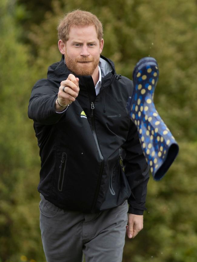 Prince Harry take his shot at welly wanging. Picture: Greg Bowker/AFP