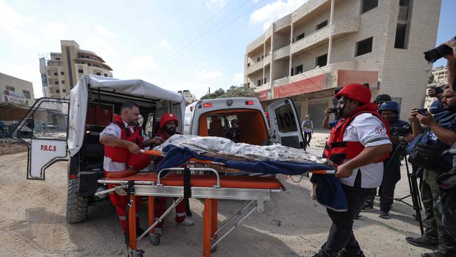 Palestinian Red Crescent rescue workers evacuate the body of a man killed on the second day of a large-scale military operation on the Nur Shams refugee camp in Tulkarem in the occupied West Bank on August 29, 2024. The death toll climbed on August 29 as the Israeli army said it killed five militants in Tulkarem, bringing to 14 the overall number of people killed since the launch of the West Bank operation the previous day. (Photo by JAAFAR ASHTIYEH / AFP)