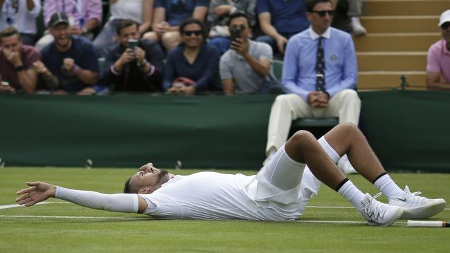 Australia's Nick Kyrgios lays on the court after diving for a shot by Australia's Jordan Thompson