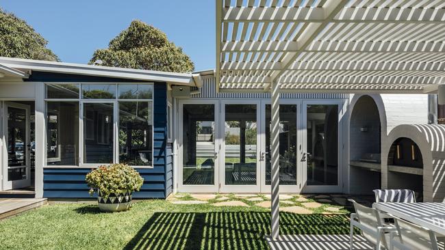 Timber slats cast lovely shadows, while paving connects the house to the outdoors.