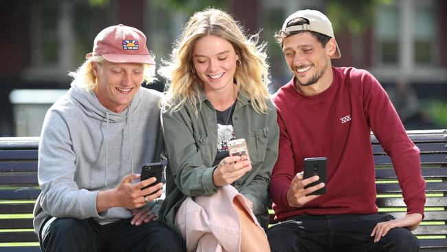 Callum Sadberry, Claudia Talon and Florian Sohier check their phones. Picture: Alex Coppel. 