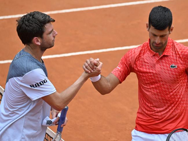 Britain's Cameron Norrie (L) and Serbia's Novak Djokovic shake hands after Djokovic won their fourth round match of the Men's ATP Rome Open tennis tournament at Foro Italico in Rome on May 16, 2023. (Photo by Tiziana FABI / AFP)