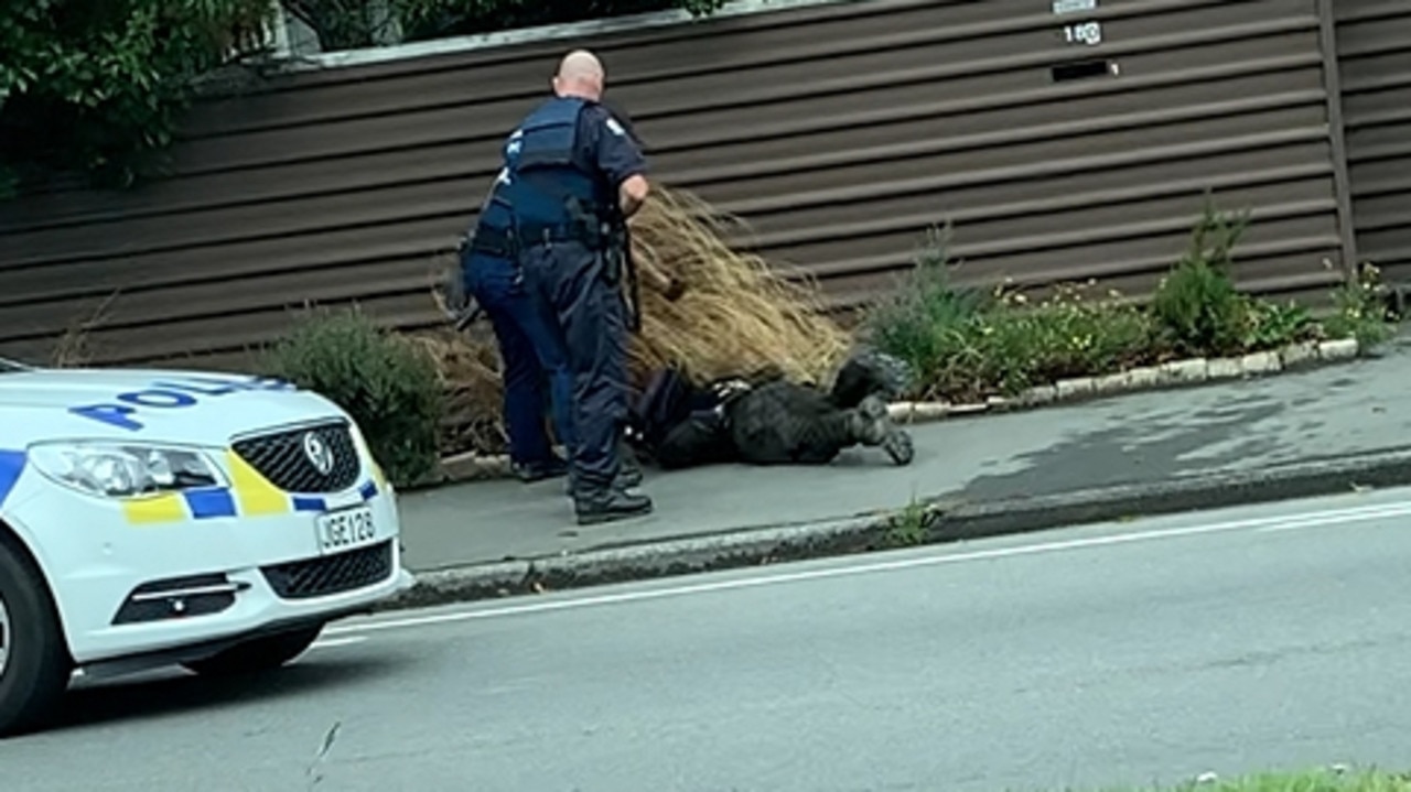 New Zealand Police officers arrest accused Christchurch gunman Brenton Tarrant.