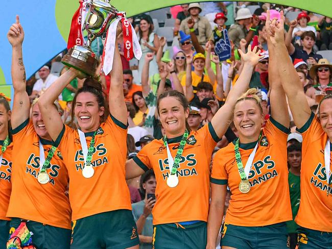 TOPSHOT - Australia's Charlotte Caslick (C) lifts the trophy with her teammates after Australia won the women's HSBC World Rugby Sevens Series 2023 final match between Australia and France at the Cape Town stadium in Cape Town on December 10, 2023. (Photo by Rodger Bosch / AFP)