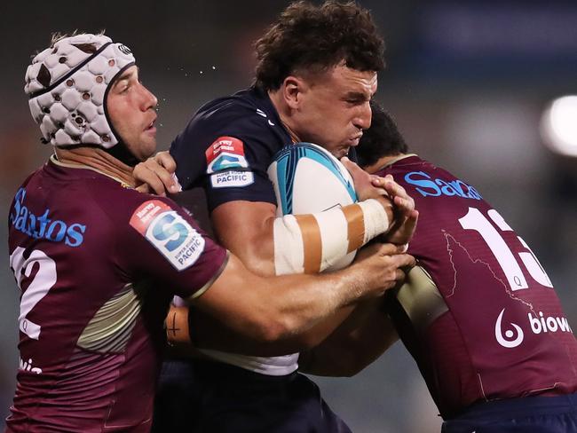 CANBERRA, AUSTRALIA - MARCH 18:  Tom Banks of the Brumbies is tackled during the round five Super Rugby Pacific match between the ACT Brumbies and the Queensland Reds at GIO Stadium on March 18, 2022 in Canberra, Australia. (Photo by Matt King/Getty Images)