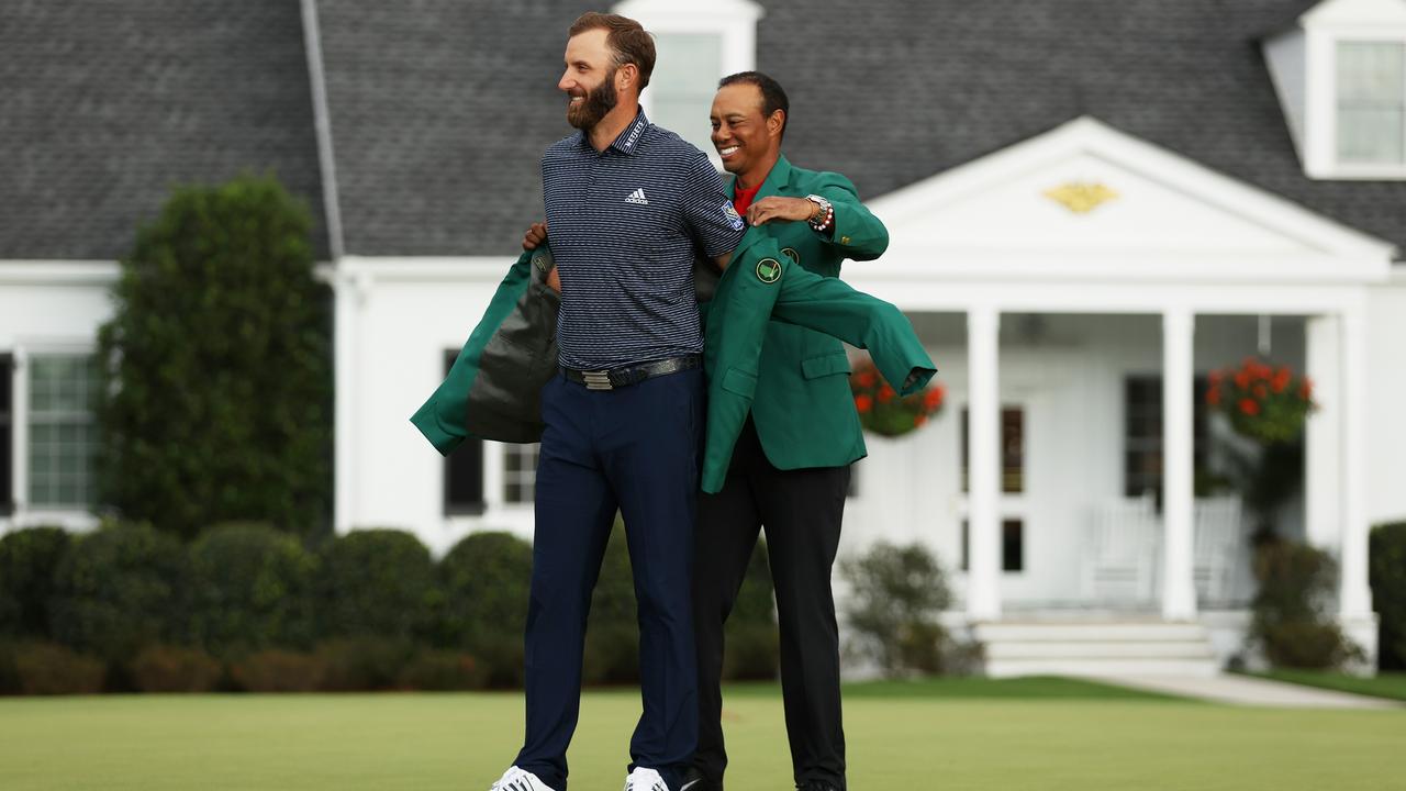 Dustin Johnson is awarded the Green Jacket by Masters champion Tiger Woods. (Photo by Patrick Smith/Getty Images)