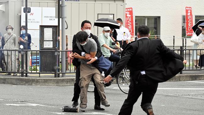 Tetsuya Yamagami being tackled to the ground by police at Yamato Saidaiji Station in the city of Nara. Picture: Getty Images