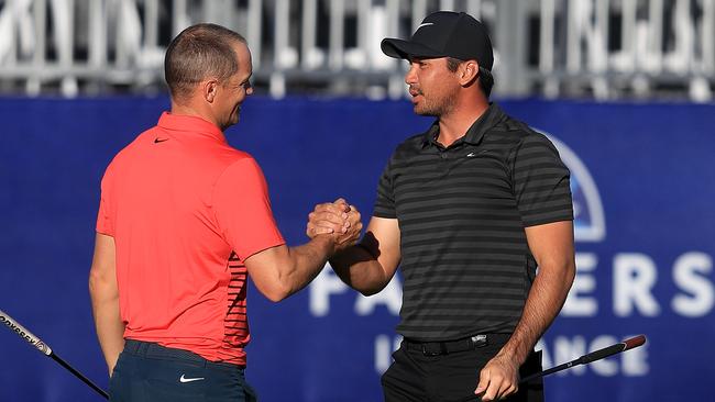 Jason Day shakes hands with Alex Noren of Sweden on the sixth playoff on the 18th green after the Australian won the Farmers Insurance Open at Torrey Pines.