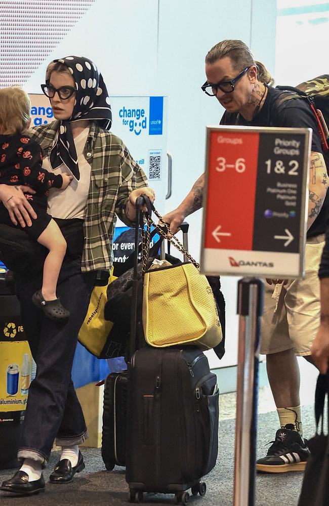 The couple make a low-key exit through Sydney airport, with son Sidney in tow. Picture: MEDIA-MODE.COM