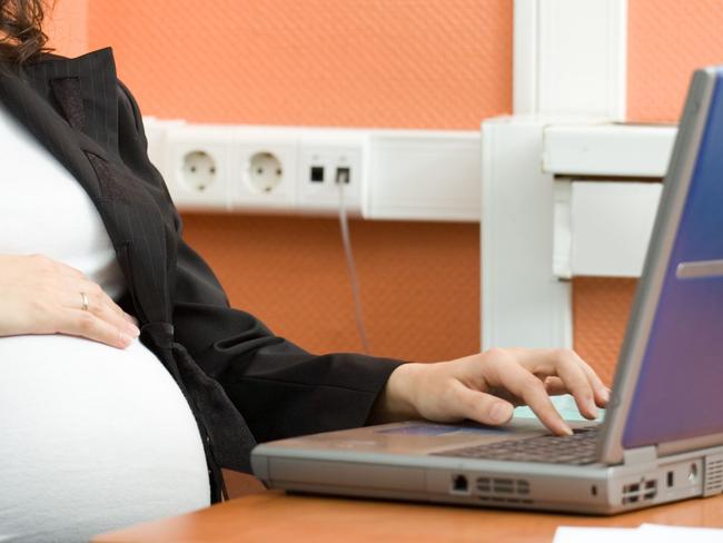 Pregnant woman at work. Thinkstock.