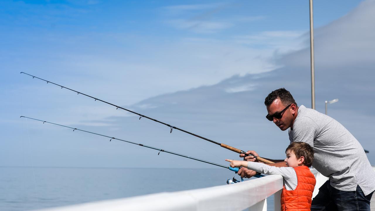 Joshua Quinn and his son Cohen, 3, fishing off the Grange jetty. Picture: AAP/Russell Millard