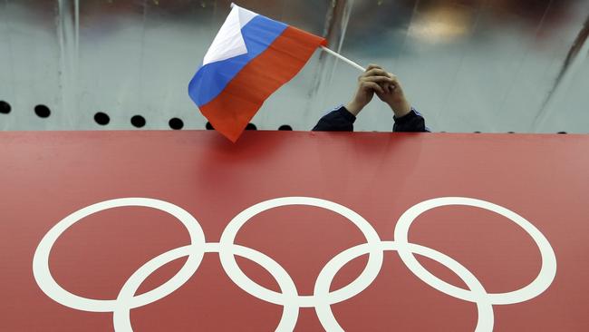 FILE - In this Feb. 18, 2014, file photo, a Russian skating fan holds the country's national flag over the Olympic rings before the men's 10,000-meter speedskating race at Adler Arena Skating Center during the Winter Olympics in Sochi, Russia. Formed with good intentions, the World Anti-Doping Agency finds itself at a crossroads as it celebrates its 20th anniversary at a conference this week in Poland. Itâ€™s an agency riven with conflicts that have hindered its fight against drugs and exacerbated its 4-year-old struggle in the high-profile case against Russia. (AP Photo/David J. Phillip, File)