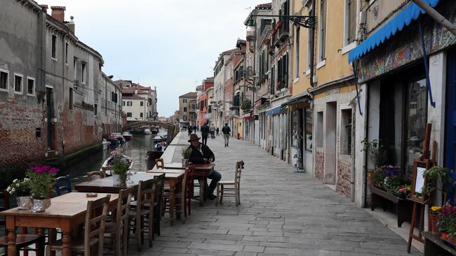 A sole Venetian sits outside the historical cafe 'The lost Paradise'. All restaurants and bars have been ordered closed. Picture; Getty Images.