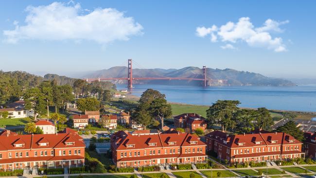 An aerial view of the Golden Gate Bridge and the Presidio. A beautiful blue sky with a hint of low fog.