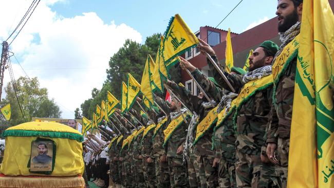 Hezbollah members salute during the funeral of a comrade who was killed by the explosion of a communication device. Picture: AFP