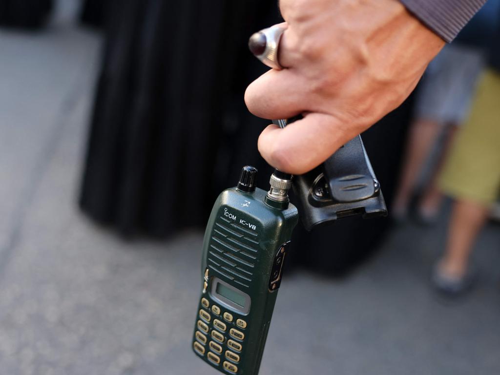 A man holds a walkie talkie device after he removed the battery during the funeral of people killed when hundreds of paging devices exploded in a deadly wave across Lebanon. Picture: AFP